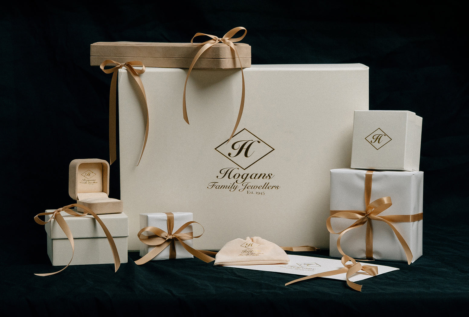 Hogans Family Jewellers gift boxes and wrapped gifts with gold ribbon.