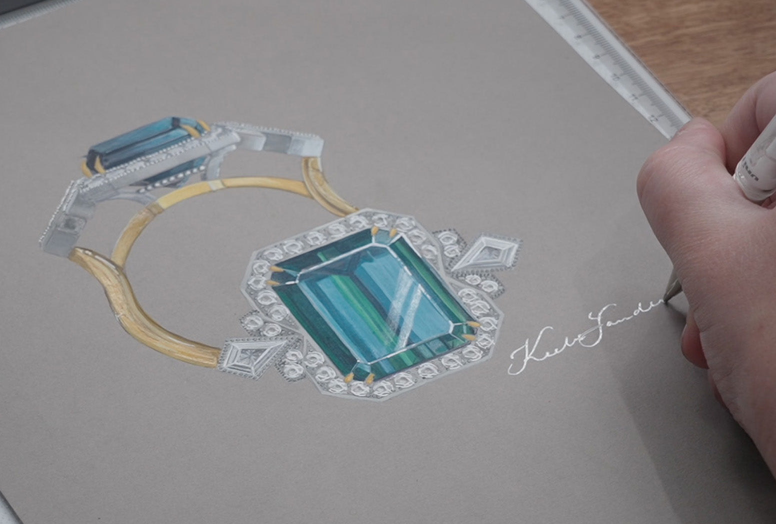 Jeweller signing name after completing bespoke watercolour painting.