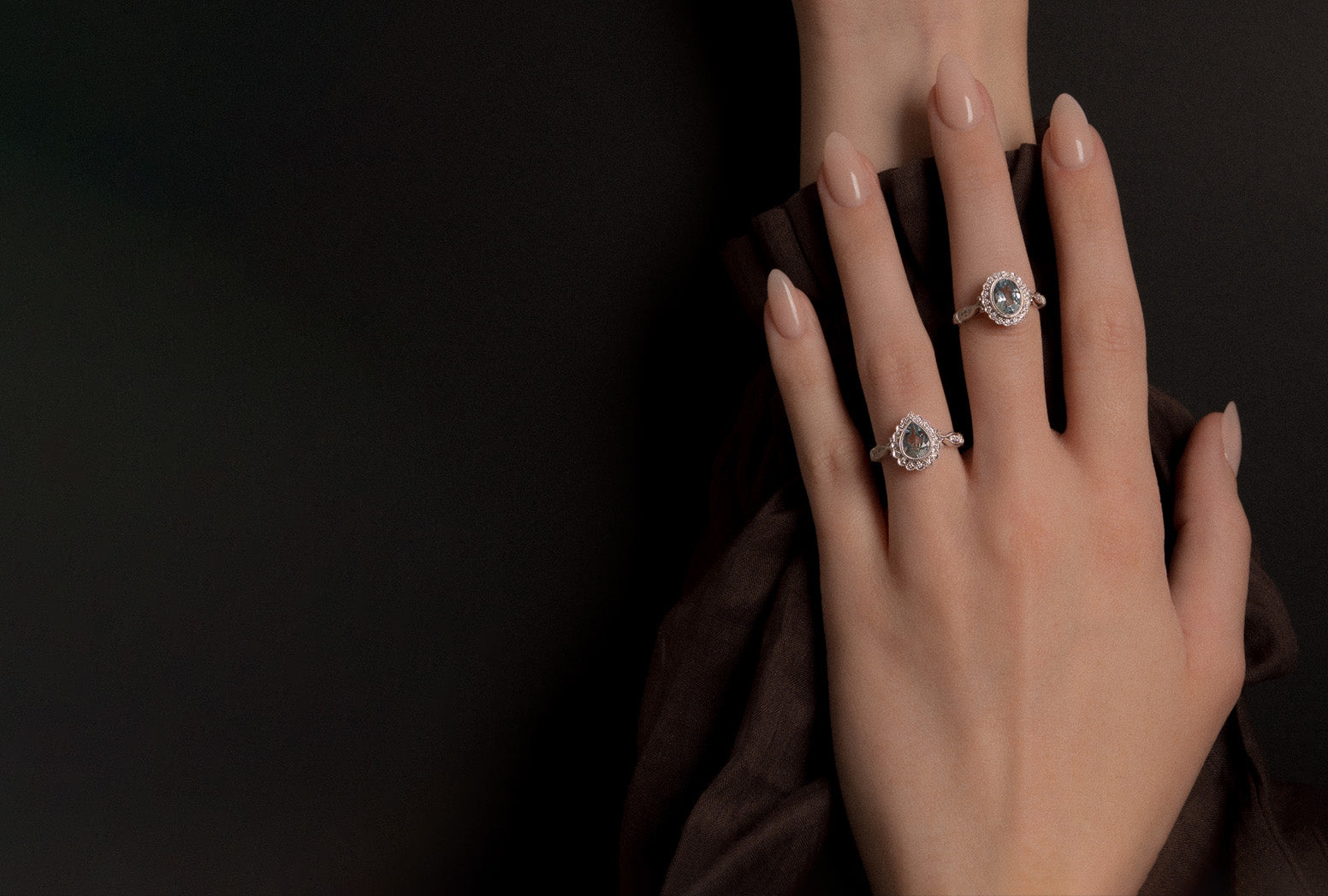 White gold aquamarine and natural white diamond dress rings modelled.