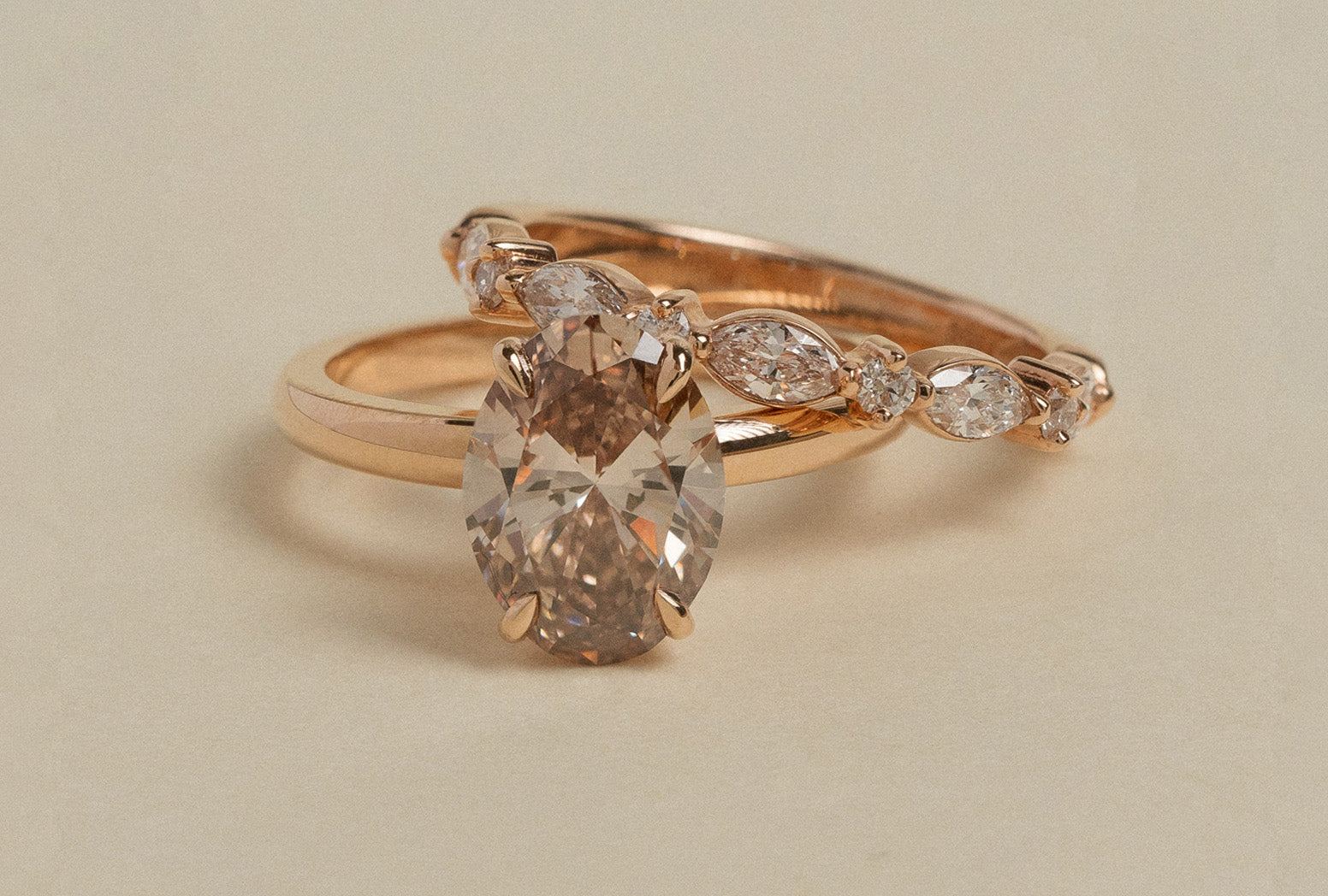 Rose gold set with oval cut solitaire champagne diamond engagement ring and wedding band with marquise and round brilliant cut natural white diamonds.