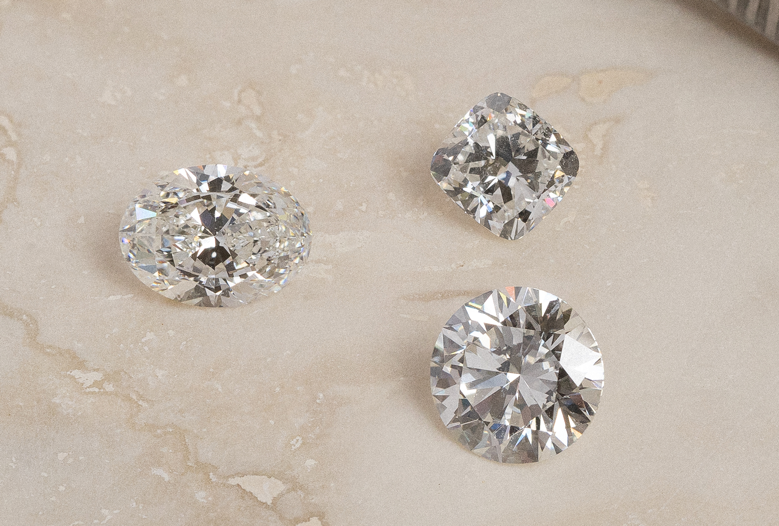 Cushion, oval, and round brilliant cut natural white diamonds.