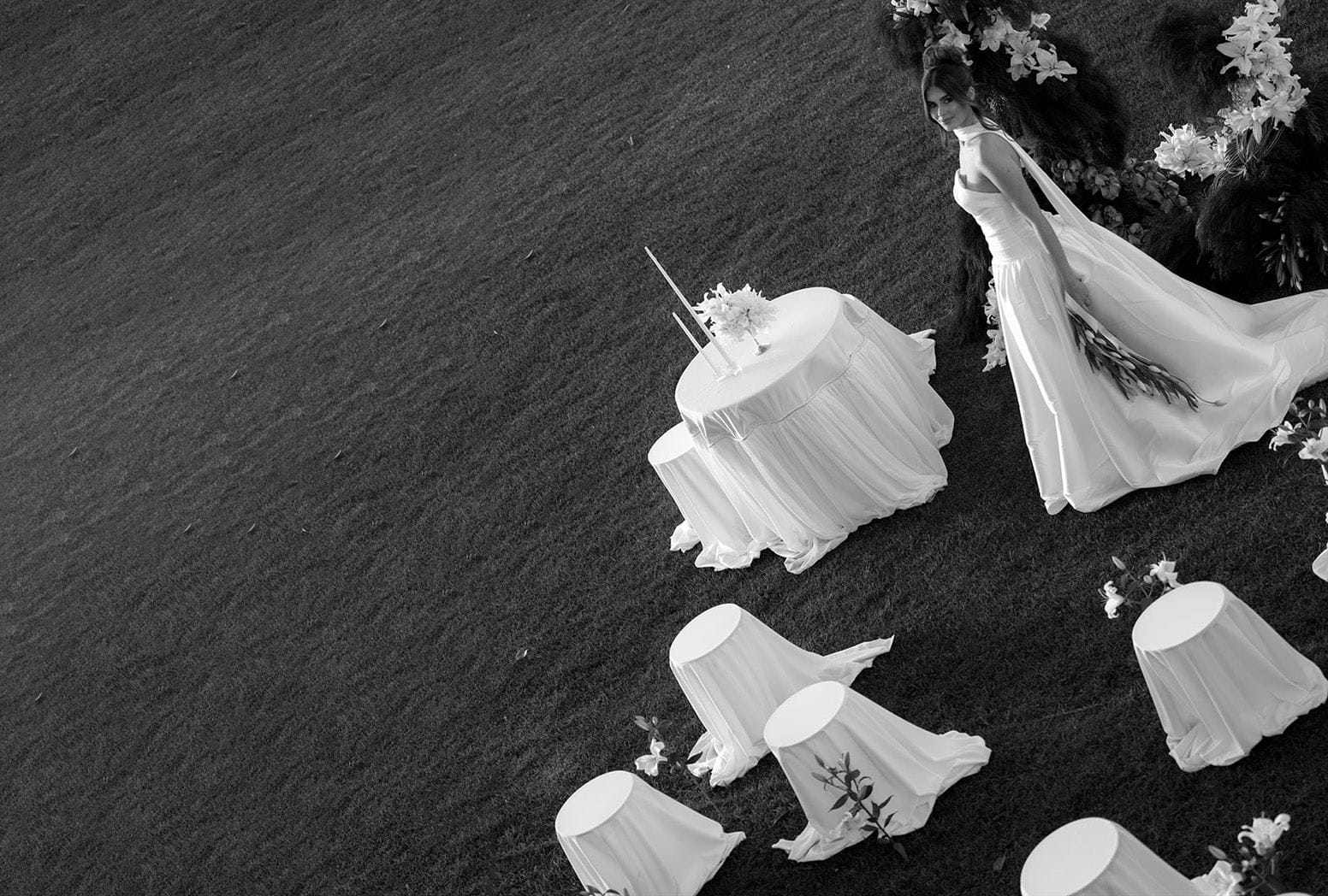 Lifestyle photo of bride amongst tables with white tablecloths.