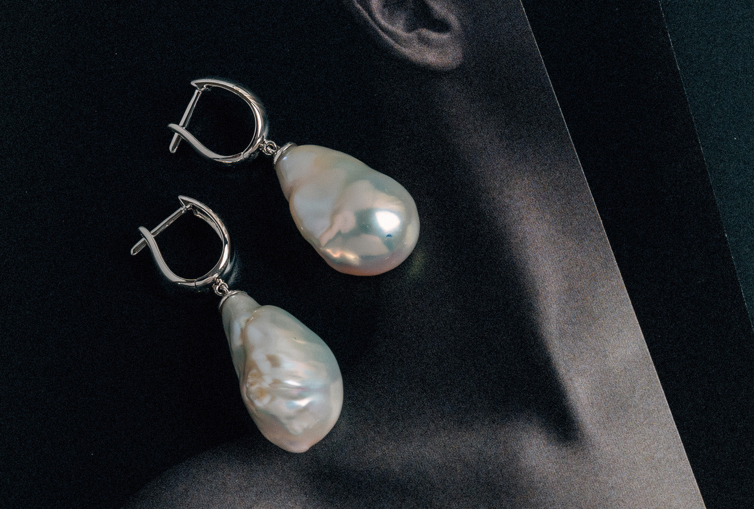Modelled photo with white metal baroque pearl huggie earrings.