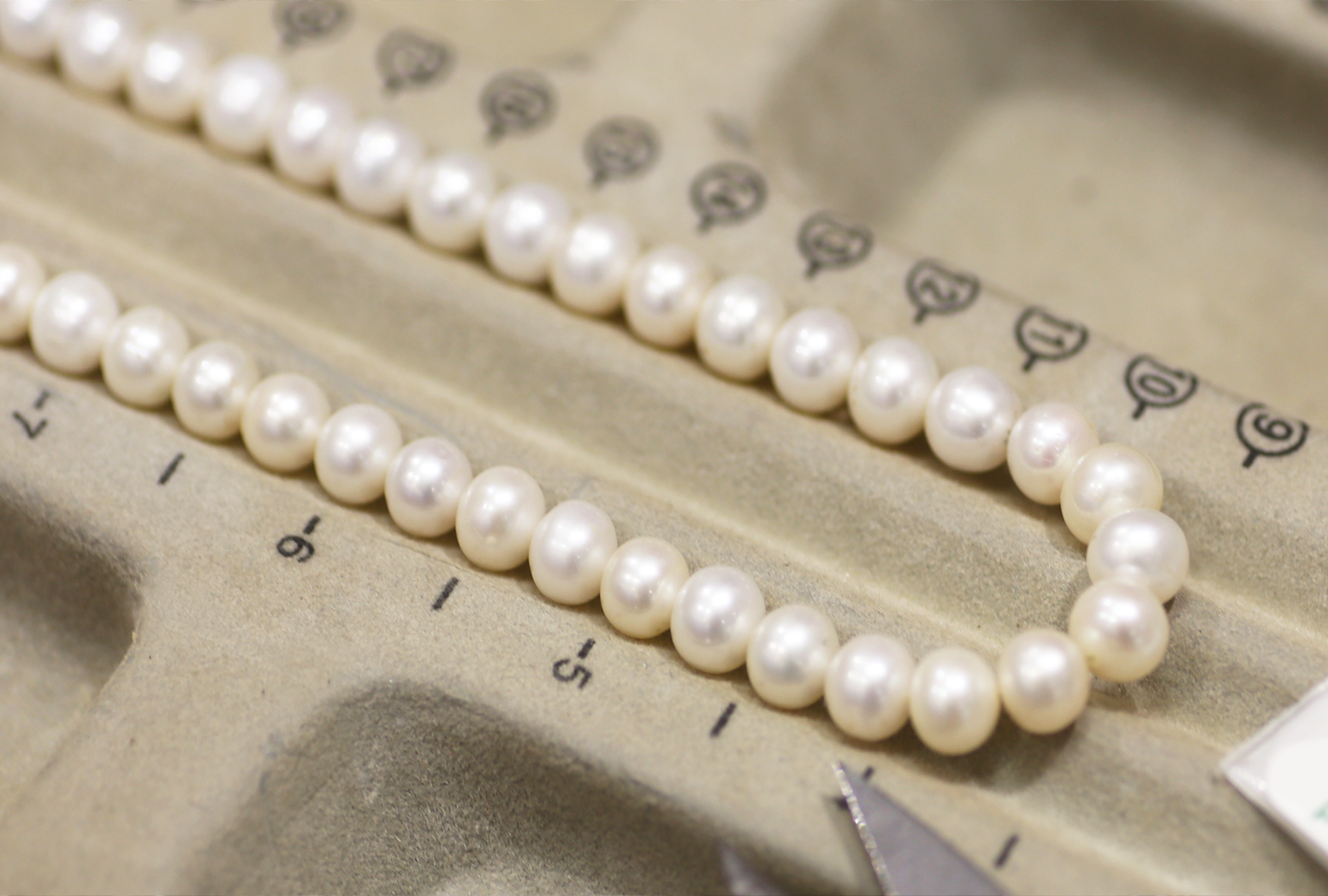 White pearls on a pearl beading tray.