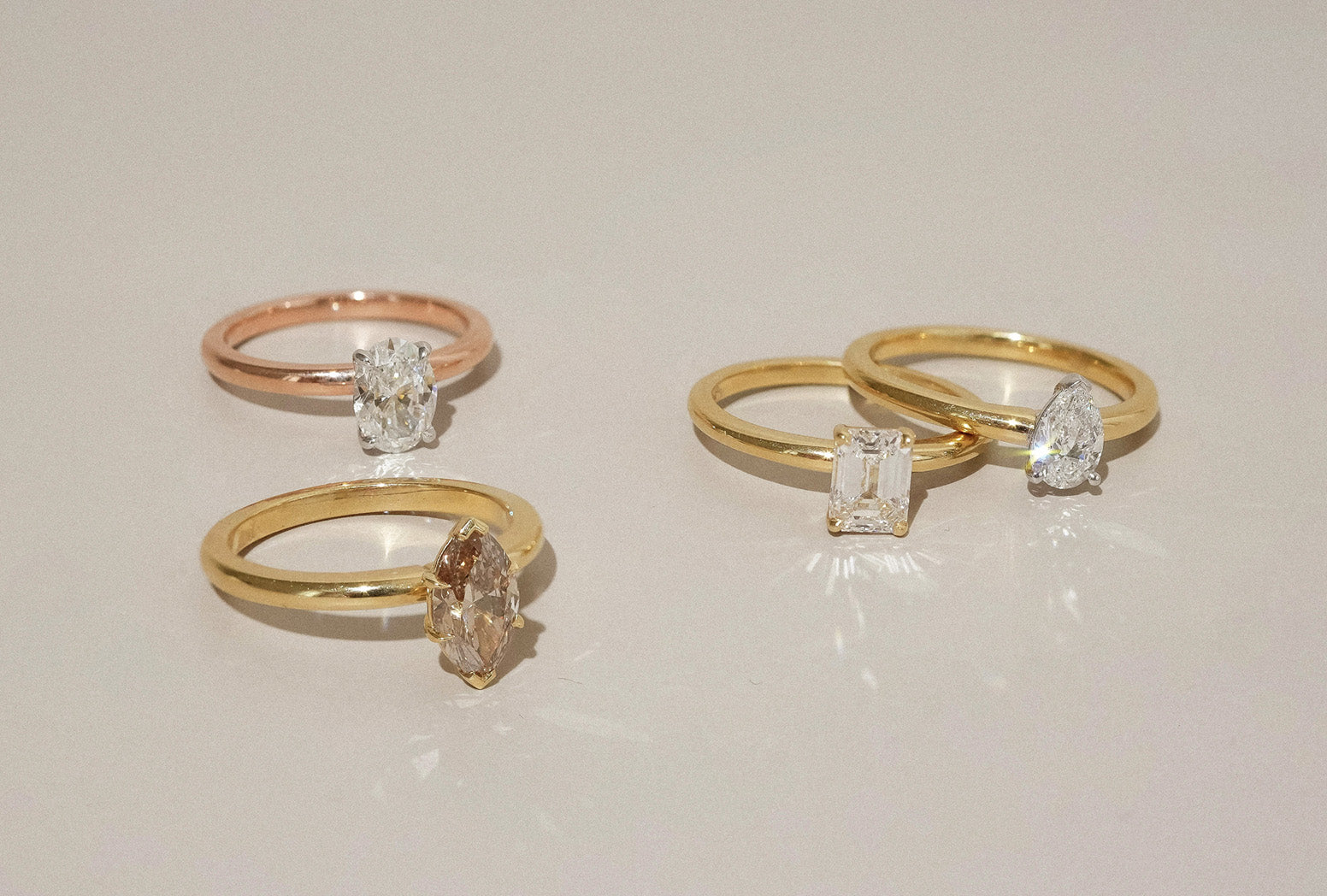 Array of solitaire engagement rings in yellow, white and rose gold with pearl, oval, emerald and marquise cut natural white and champagne diamonds.