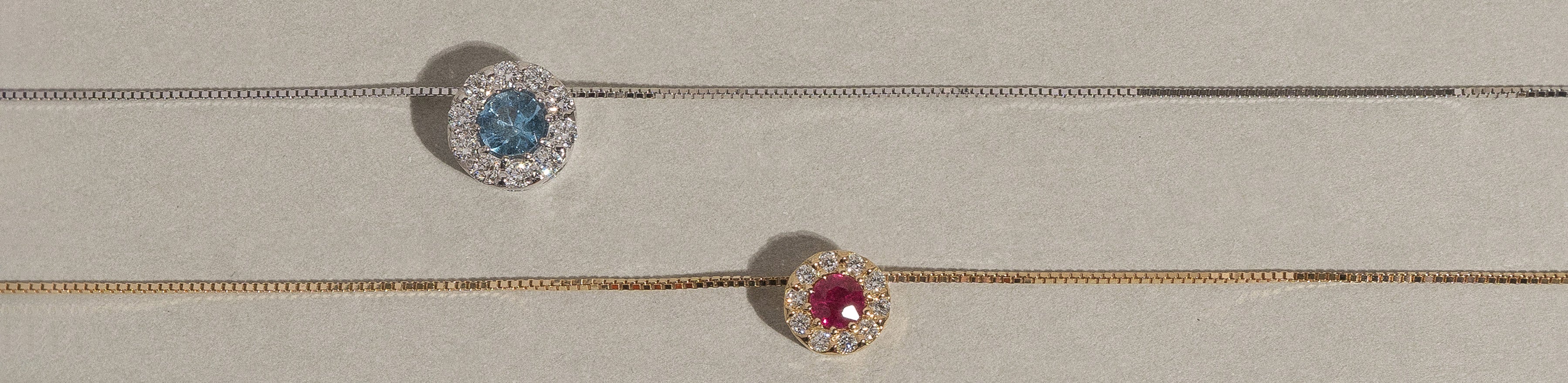 Yellow and white gold necklaces with ruby, aquamarine, and natural white diamonds.