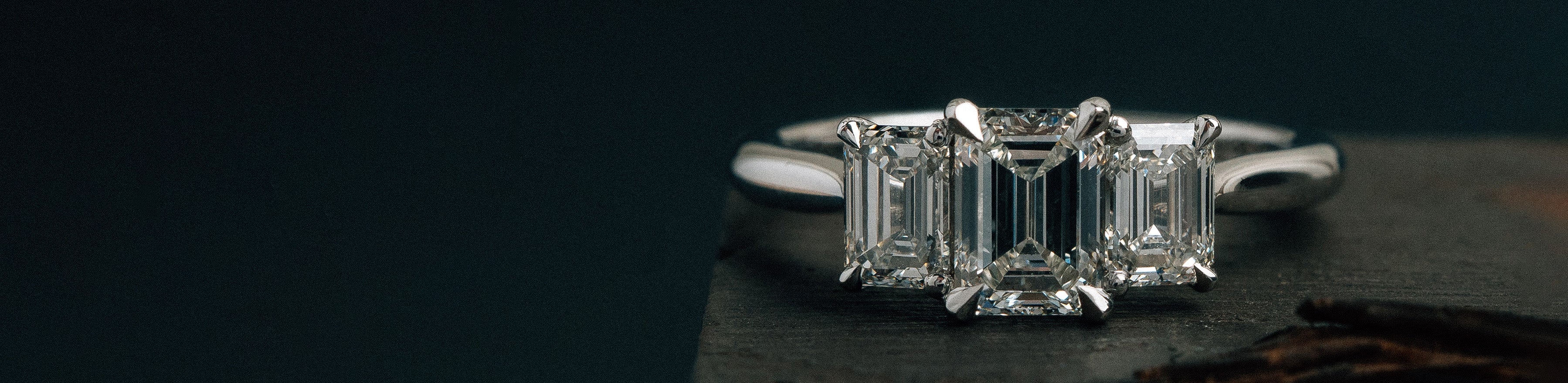 White gold trilogy ring with natural emerald cut white diamonds.