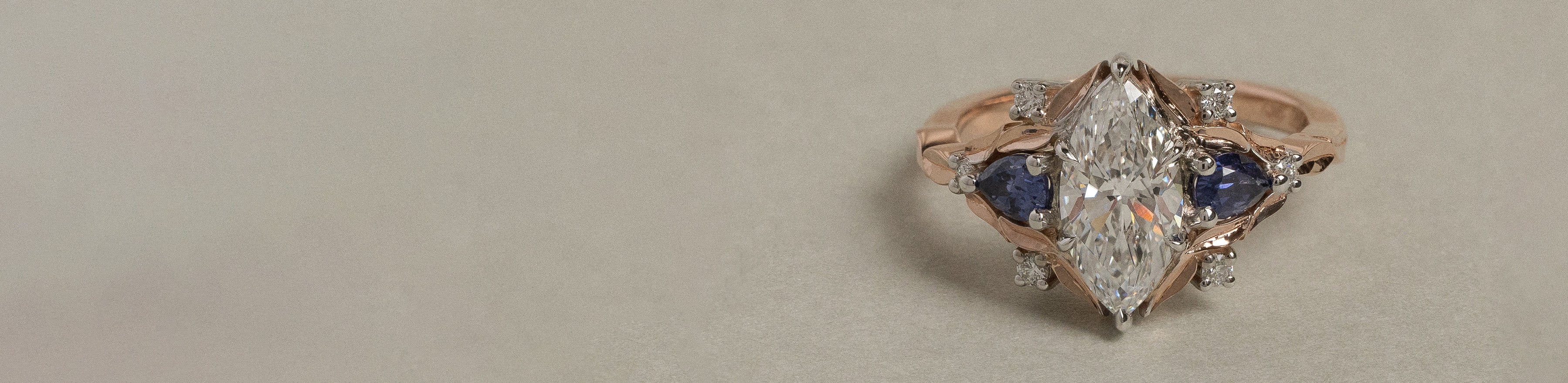 18k rose and white gold cluster ring with white natural marquise and round brilliant cut diamonds, and pear cut purple sapphires.