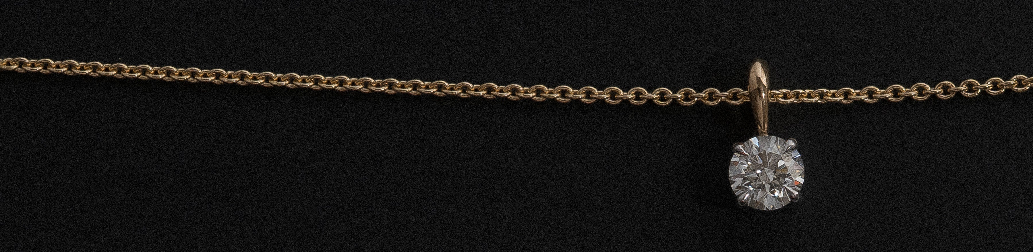 18k yellow and white gold round brilliant cut solitaire pendant with a natural white diamond on a fine trace chain.