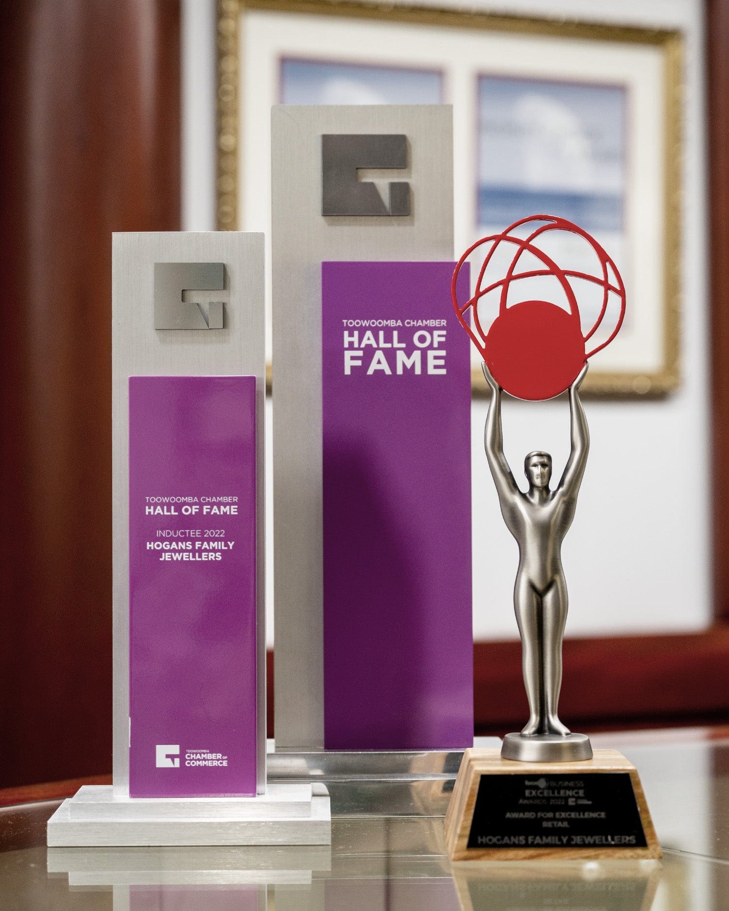 Three trophies grouped together including the Toowoomba Chamber Hall of Fame Inductee 2022 Trophy with Hogans Family Jewellers detailed.