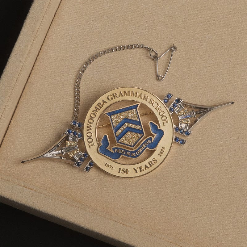 Custom made Toowoomba Grammar School brooch in beige pendant box on black background.