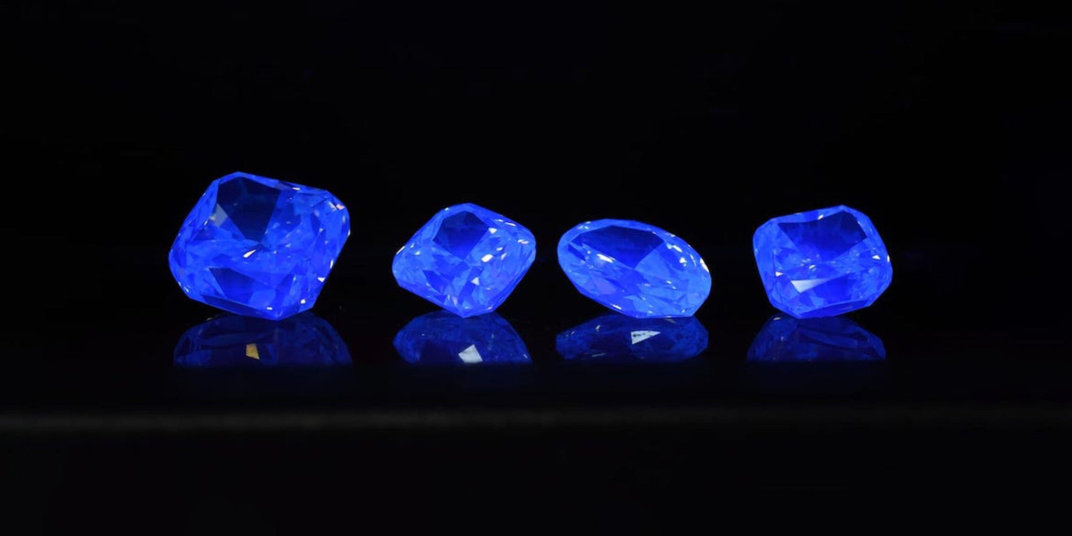 Four loose diamonds under fluorescent light.