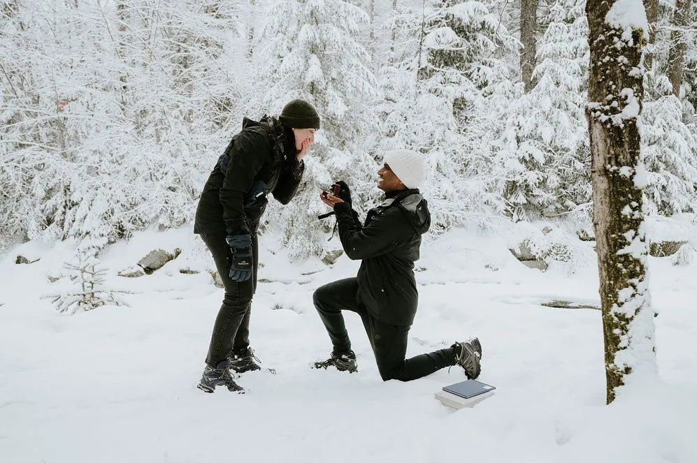 Couple proposing in snow covered forest in Canada.