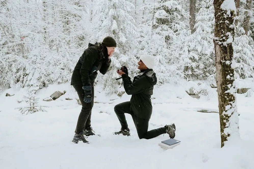 Couple proposing in snow covered forest in Whistler, Canada.