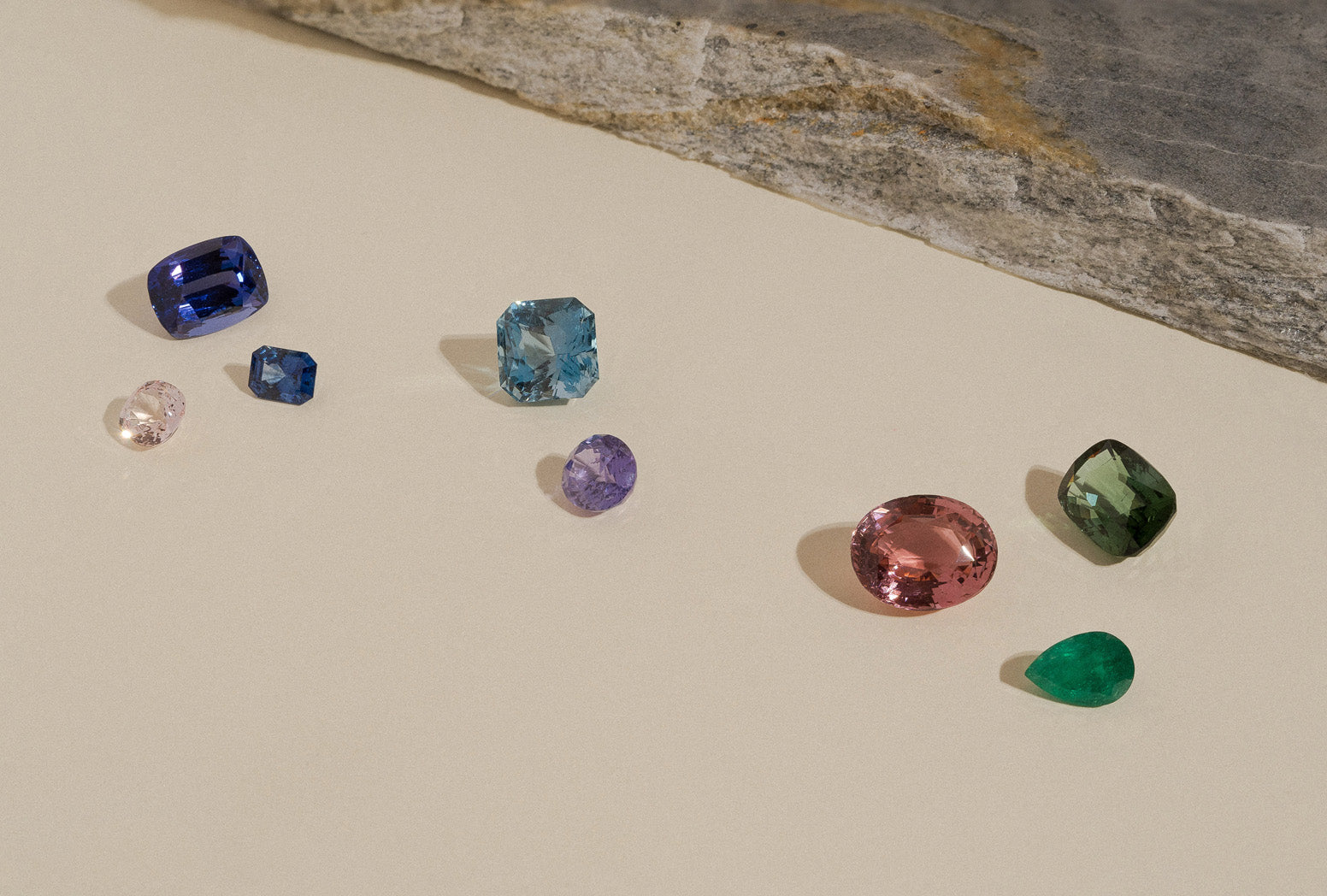 An assortment of loose faceted natural gemstones.