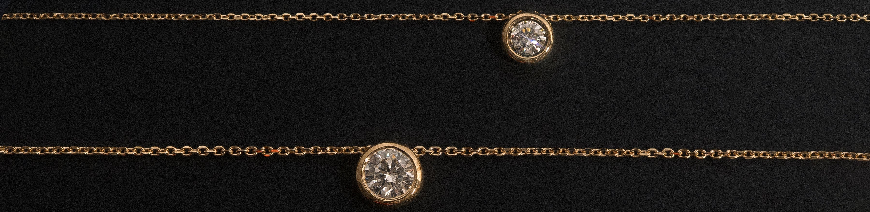 Yellow gold round brilliant cut natural diamond bezel set necklace on a black background.