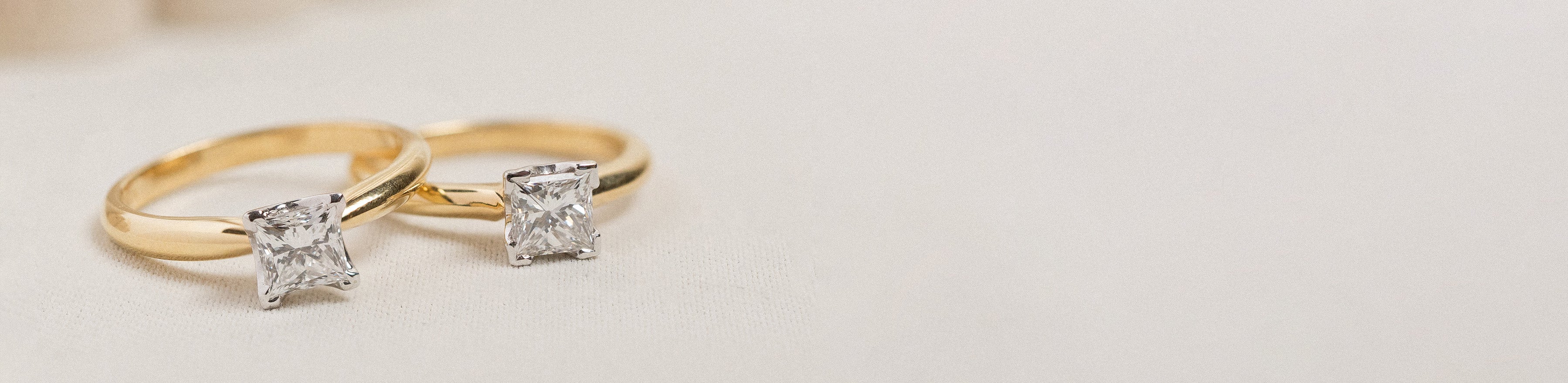 18k yellow and white gold princess cut solitaire rings with natural white diamonds.