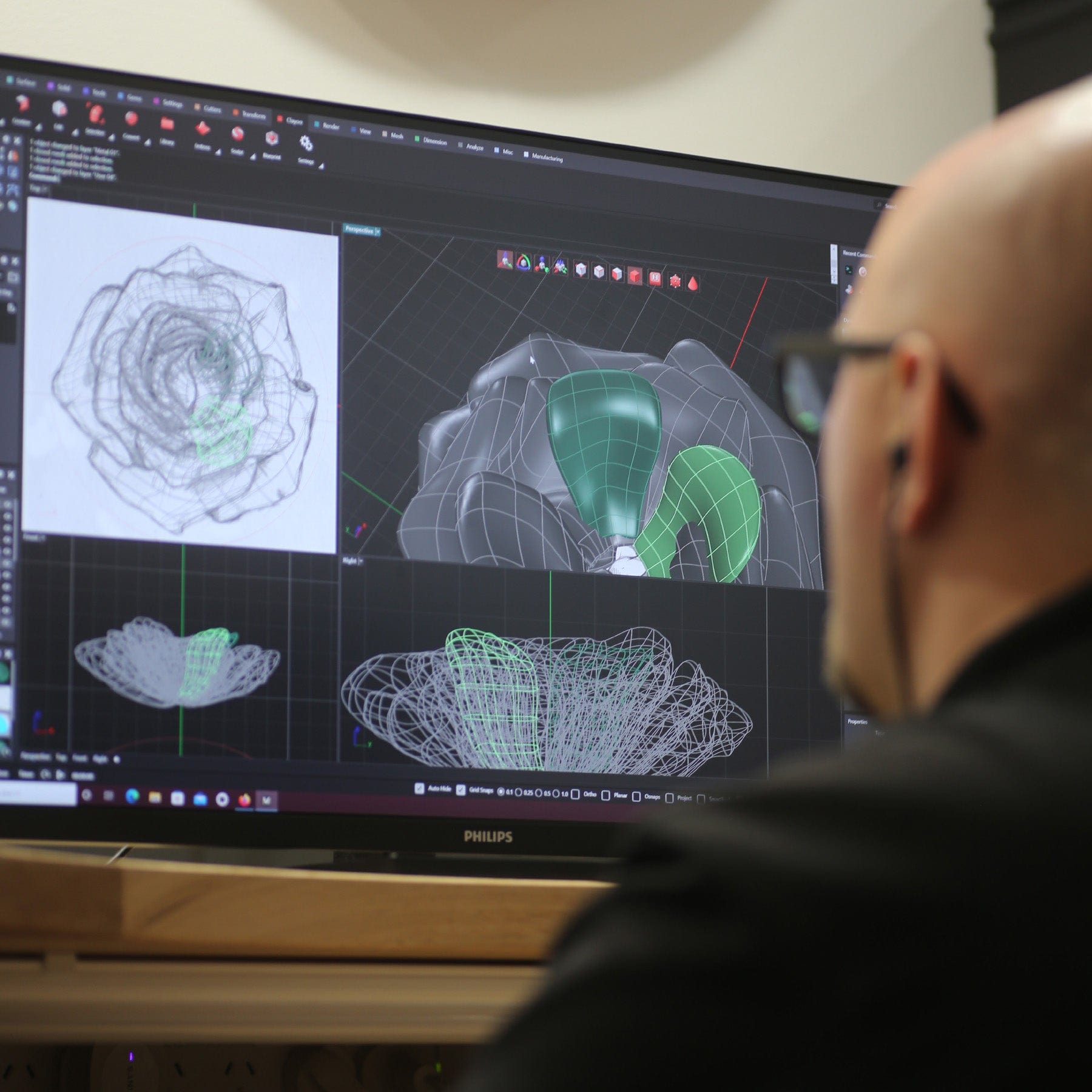 Jeweller on computer cadding a rose style ring.