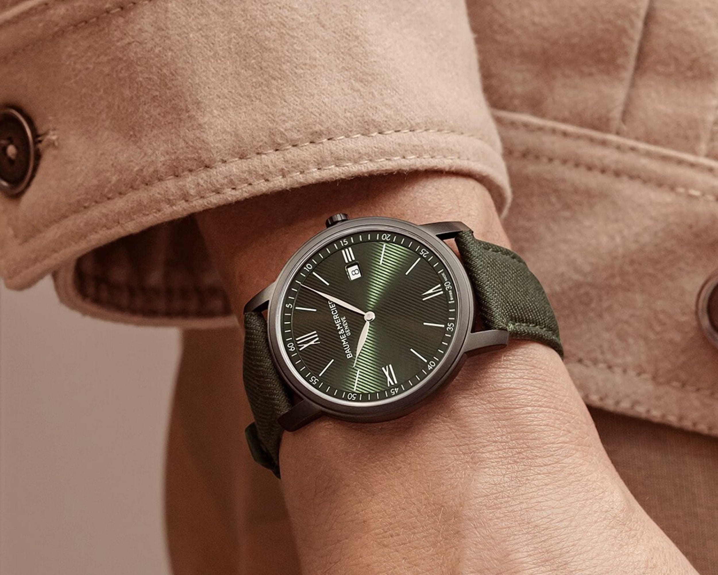 Male model wearing Baume & Mercier 10766 khaki coloured watch and camel coloured jacket.