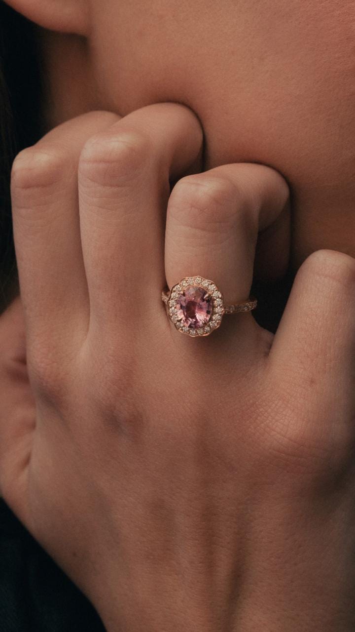 Model wearing rose gold pink sapphire and diamond cluster ring